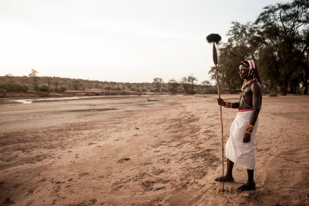 Samburu warrior with spear by the riverbed